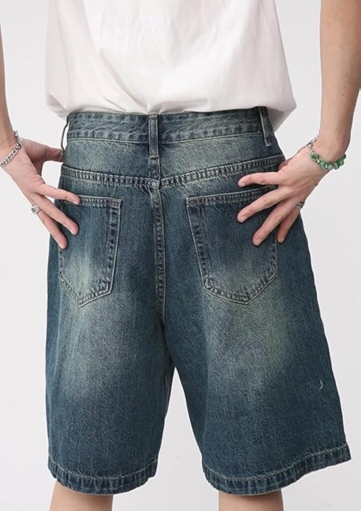 Flat lay of high-waisted denim jorts folded on white bedding with minimal styling