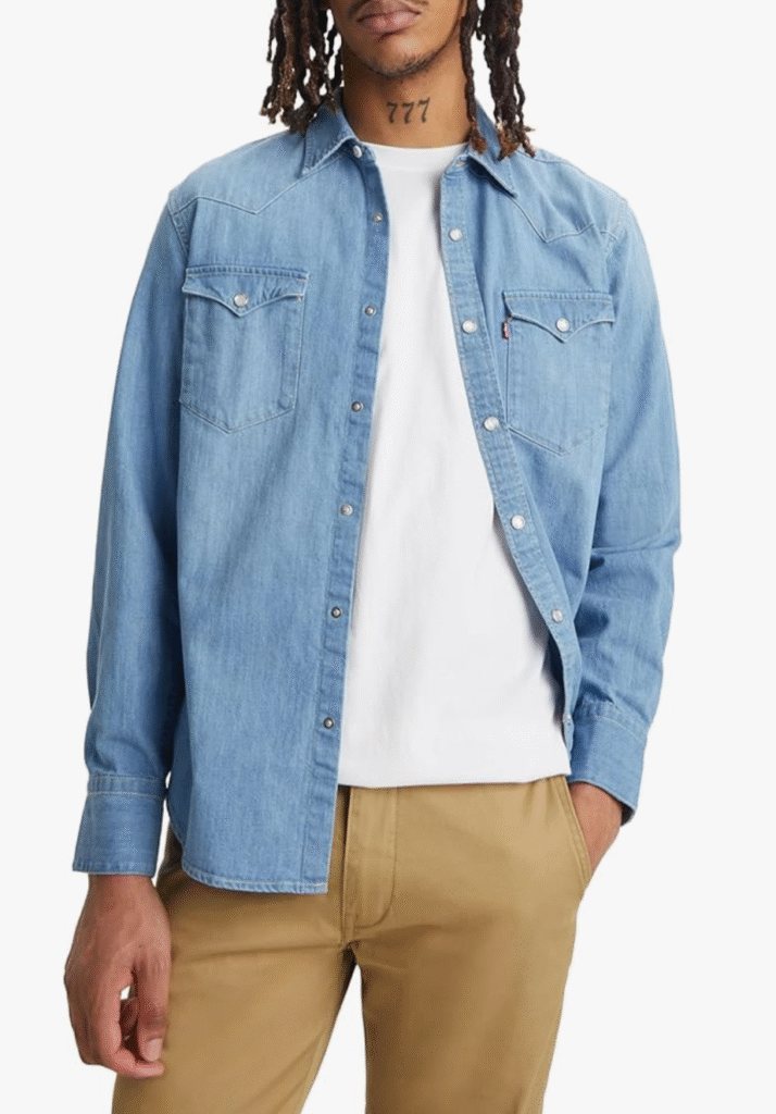 Model wearing Levi’s denim shirt open over white tee with beige chinos