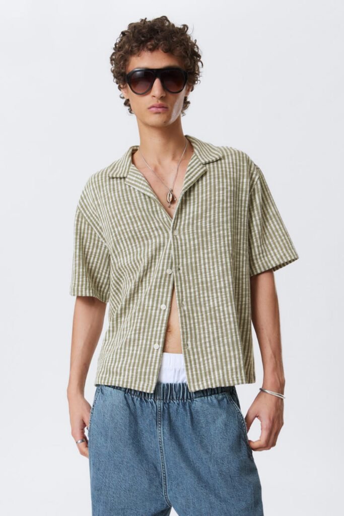 Model wearing a green striped short sleeve summer shirt with a relaxed collar. men's summer shirts