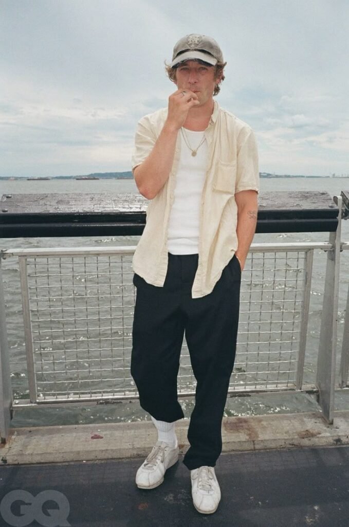 Jeremy Allen White wearing a cream short sleeve shirt with relaxed summer styling.