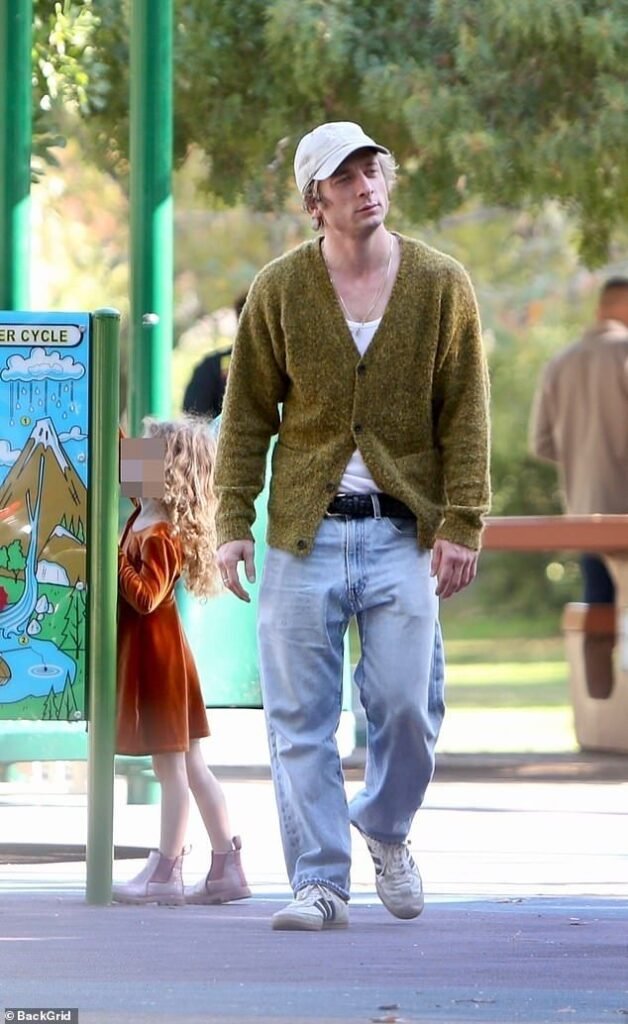 Jeremy Allen White wearing a green mohair cardigan with light denim and sneakers.