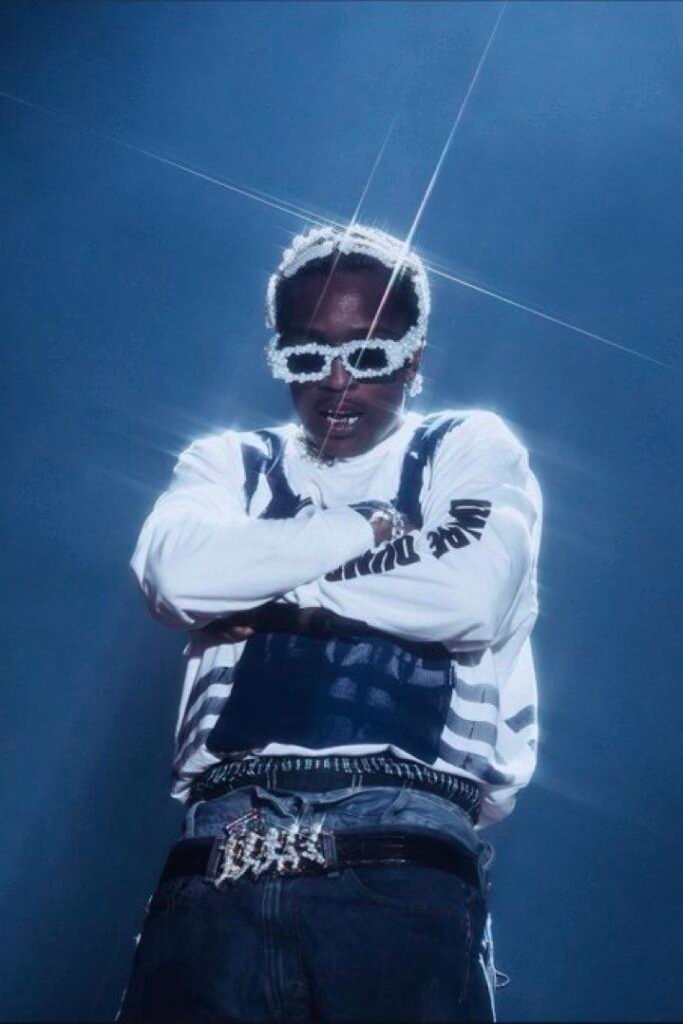 ASAP Rocky on stage in armour-graphic streetwear and an iced-out Don’t Be Dumb belt.