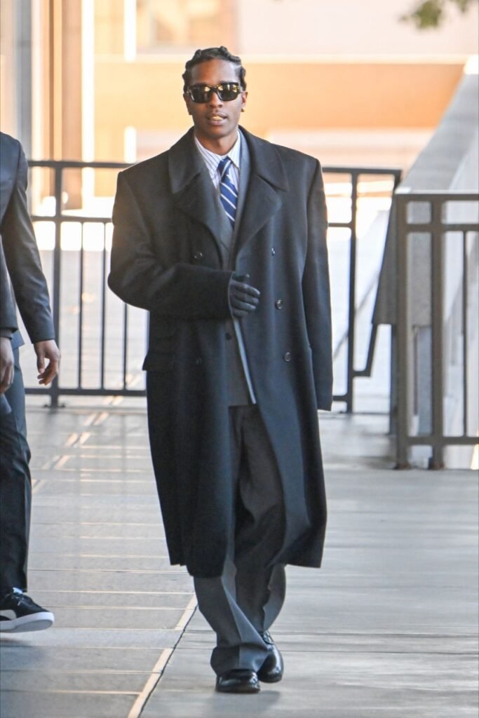 ASAP Rocky in a massive double-breasted coat with gloves, sunglasses, and a blue tie.