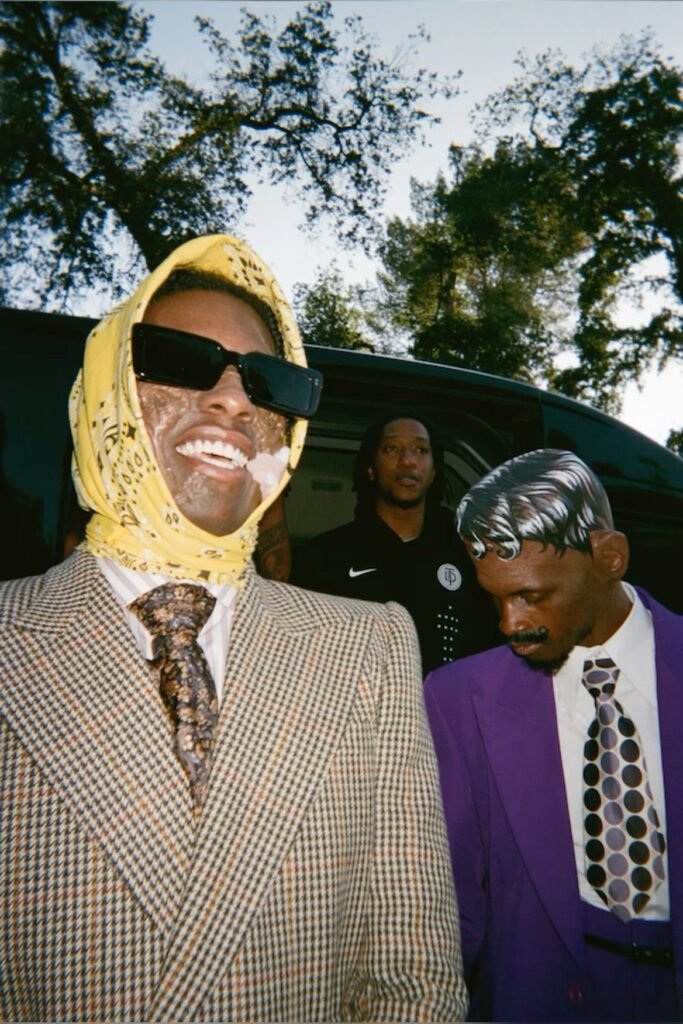 ASAP Rocky in a vintage houndstooth suit, paisley tie, and yellow babushka scarf.
