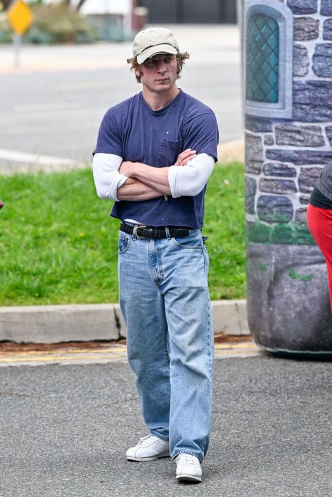 Jeremy Allen White outfits layering a cream thermal under a navy t-shirt with jeans.