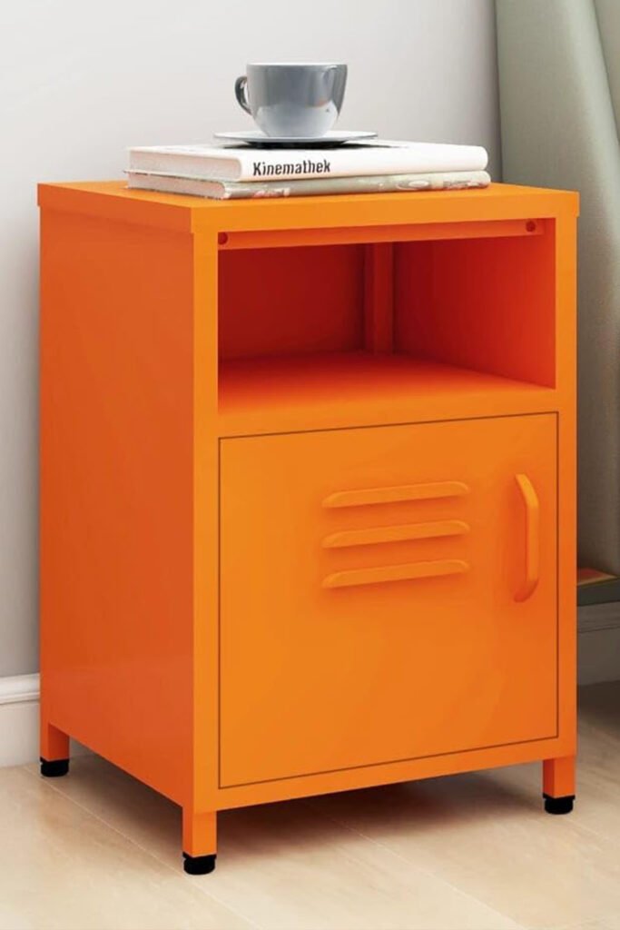 Bright orange metal side table with a locker-style cabinet and open shelf, placed beside a bed.