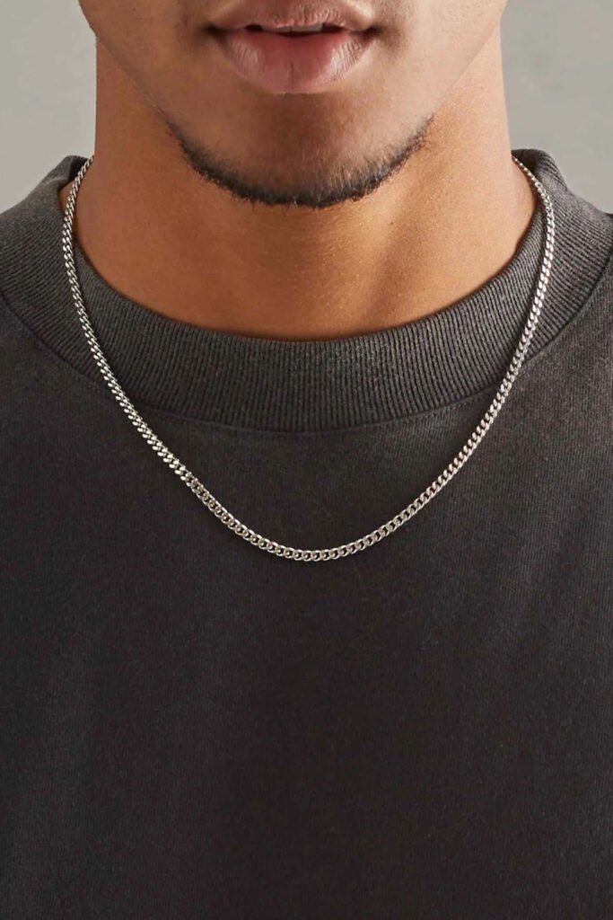 mens jewellery essentials Dainty silver Cuban chain necklace worn with a black sweatshirt