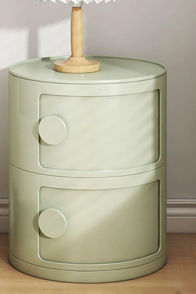 Cylindrical sage green bedside table with two circular-handled drawers.